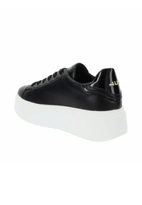 Baskets en cuir synthétique noir avec une épaisse semelle blanche, présentant un accent noir brillant au niveau du talon et un détail de logo doré à l'arrière.
