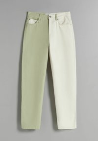 Pantalones bicolor con lado izquierdo verde y lado derecho blanco, hechos de algodón, con cinco bolsillos y un diseño de pierna recta.