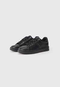 Sneakers low-top in pelle nera con lacci, occhielli in metallo e logo "GUESS" sul lato e sulla suola, esposti su uno sfondo bianco.