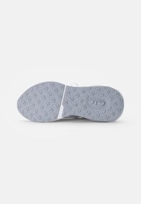 Suela de zapato de goma gris con un patrón texturizado y una sección central blanca. Destaca por sus formas onduladas y las indentaciones circulares para la tracción.