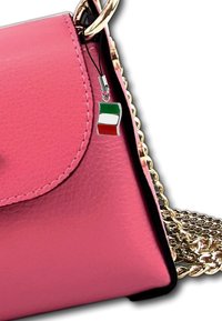 Roze faux leren handtas met een zwarte rand, gouden schouderband en een klein hangertje met de Italiaanse vlag. Gladde textuur, rond klepontwerp.