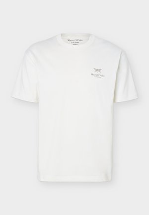 T-shirt blanc à manches courtes et col rond avec petit papillon noir et texte « Marc O’Polo » sur le côté gauche de la poitrine.