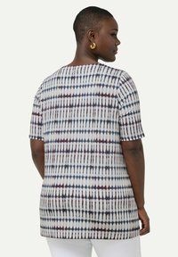 Camicetta a maniche corte con un design a motivo in bianco, blu e burdeos. Presenta una vestibilità ampia e un orlo curvo sul retro.