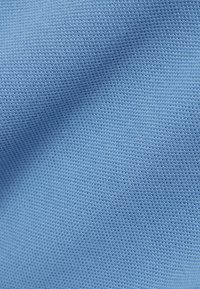 Hellblaues, strukturiertes Gewebe mit feinem Netzmuster, das eine glatte und weiche Oberfläche zeigt. Keine sichtbaren Muster oder Verzierungen.