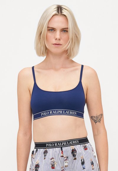 Granatowy bralet wykonany z miękkiego materiału, z cienkimi ramiączkami i paskiem z logo „POLO RALPH LAUREN”, gładka faktura oraz prosty design.