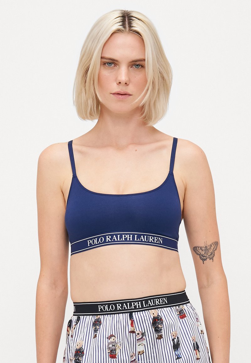 Námornícky modrý bralet vyrobený z mäkkého materiálu, s tenkými ramienkami a pásom s logom "POLO RALPH LAUREN", hladká textura a jednoduchý dizajn.
