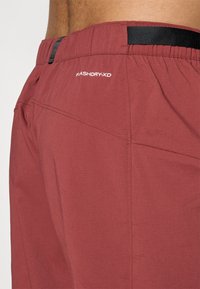 Bordo kratke hlače s teksturiranom tkaninom, elastičnim pojasom i crnim detaljem. Na stražnjoj strani imaju oznaku "FLASHDRY-XD".