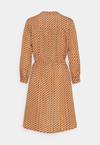 Orange mönstrad klänning med samlad midja, knäppt bak och lång ärm. Har ett geometriskt mönster i vitt och svart genom hela plagg.