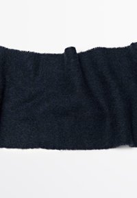 Mørkeblå uldstof med en blød, struktureret overflade. Kanterne er rå og ujævne, hvilket skaber en naturlig finish.