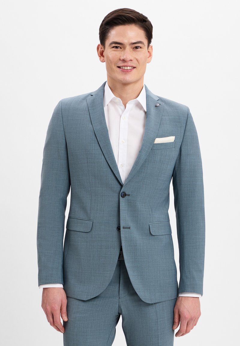 Lichtblauwe blazer met een gestructureerde afwerking, een enkelgebreide ontwerp, marineblauwe knopen en een witte pochet. Gecombineerd met een wit overhemd.