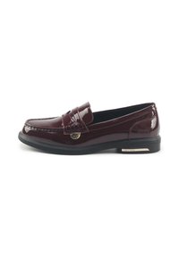 Mocasines de charol burdeos con diseño de mocasín cosido, suela plana negra y un acento de logo dorado cerca del empeine. Textura suave.