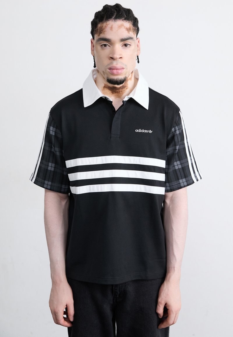 Black polo shirt with white stripes across the chest, a white collar, and plaid patterned sleeves. Features Adidas logo on the front.