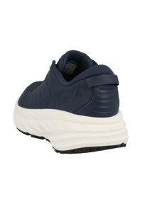 Tmavě modrá sportovní obuv s hladkým koženým svrškem, texturovanými akcenty a silnou bílou mezipodešví. Obsahuje poutko na patě.