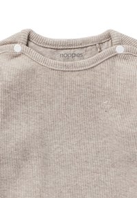 Beige geripptes Langarmshirt mit Rundhalsausschnitt, das zwei Druckknöpfe an der Schulter und ein kleines gesticktes Logo besitzt.