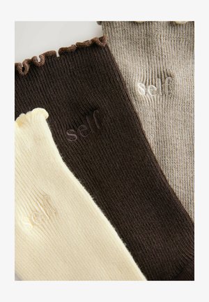 Drei Paar gerippte Socken: cremefarben mit Rüschensaum, dunkelbraun mit subtiler Logoprägung und beige mit gestreifter Textur.
