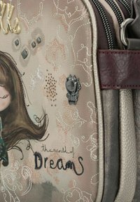 Bolso texturizado en tono rosa con diseño de chica ilustrada y acentos metálicos. Presenta costuras decorativas, gemas y un pin de gato.