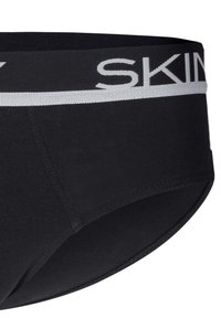 Slip in cotone nero con cintura elastica grigia recante la parola "SKIN" in maiuscolo. Texture liscia e design minimalista.