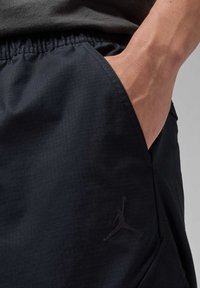 Schwarze Sportshorts aus strukturiertem Stoff, mit elastischem Bund und Seitentasche, versehen mit einem dezenten schwarzen Jumpman-Logo-Detail.