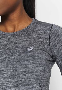 Gray athletic long-sleeve shirt featuring a textured, marled design, with a reflective logo on the left chest and a crew neckline.