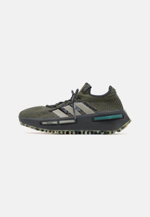 Baskets de sport tricotées vertes avec des accents gris, trois rayures blanches, une semelle texturée et un talon surélevé pour un soutien et une stabilité accrus.
