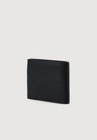 Billetera bifold de cuero negro texturizado, de pie y cerrada, sobre un fondo claro y liso.