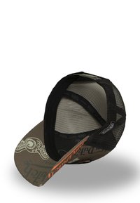 Gorra marrón con visera curva, parte trasera negra de malla y detalles gráficos que muestran un diseño de ojo. Acento naranja en la parte frontal.