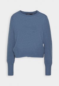 Blå stickad tröja med ett strukturerat mönster, rund halsringning och långa ärmar. Tyget ser mjukt och något stretchigt ut. Korten design.