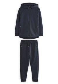 Sweatshirt à capuche marine avec fermeture éclair et deux poches latérales, associé à un pantalon de jogging assorti avec une taille élastique et des poches.