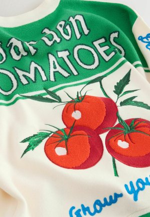Džemperis ar trim sarkaniem tomātiem un zaļām lapām uz krēmkrāsas fona, papildināts ar zaļu un zilu tekstu. Mīksts audums un adīta dizains.