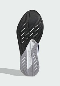 Suola di scarpe sportive nera e grigia con un motivo testurizzato e scanalature flessibili per la presa, con "LIGHTSTRIKE" impresso sul lato.