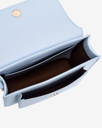 Lyseblå lædertaske med guldfarvet hardware, med en knaplukning og to inderlommer med en brun foring.