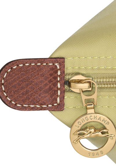 Green nylon pouch with brown leather zipper pull, featuring gold hardware and a circular charm with a galloping horse design.