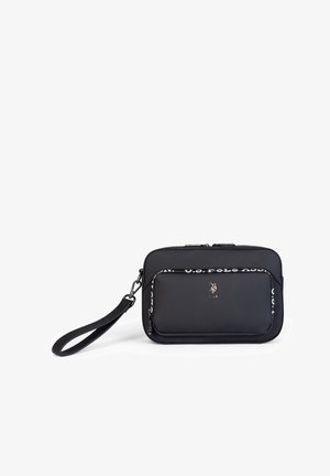 Czarna syntetyczna torebka na ramię z zamkiem błyskawicznym, z przednią kieszenią i logo U.S. Polo Assn. Zawiera odpinany pasek na nadgarstek.