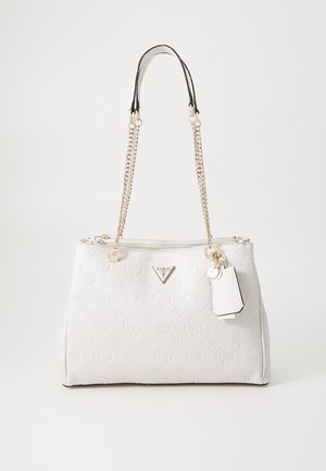 Witte Guess handtas met reliëfpatronen, gouden kettingbanden, ritssluiting en een klein aangehecht label op een effen achtergrond.