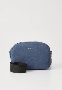 Jeans-Umhängetasche in Dunkelblau mit gesteppter Musterung, silberner Beschläge und schwarzem Logotrageband. Reißverschluss oben.