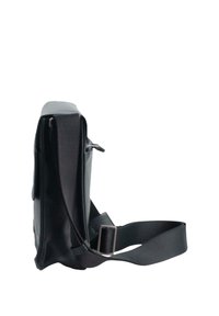 Borsa a tracolla nera realizzata in materiale sintetico liscio, con un profilo sottile, tracolla regolabile e un dettaglio con tasca laterale con zip.