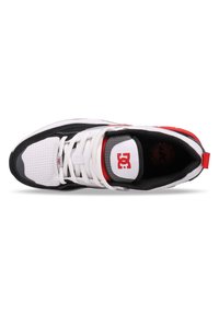 White and black sneaker with red accents, mesh upper, padded collar, and perforated detailing. Features a prominent logo on the tongue.