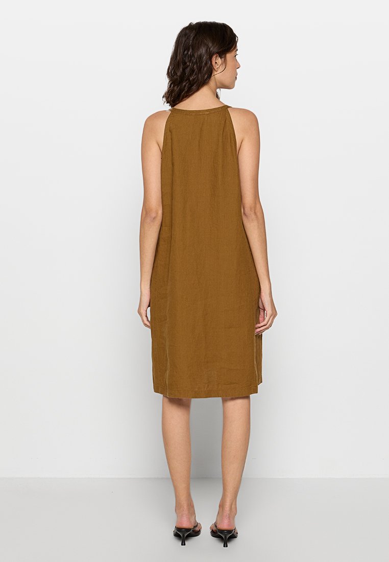 Brązowa, lniana sukienka bez rękawów, do kolan, o luźnym kroju, z prostym tyłem i minimalnymi detalami szycia.