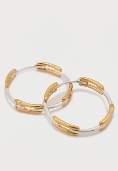 Auksinės spalvos akcentais ir sidabrine baze, sklandžiu paviršiumi ir moderniu dizainu su sujungimo detalėmis. Hoops auskarai.