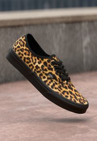 Leopardprint canvas schoen met zwarte accenten en een rubberen zool, met vetersluiting en een ronde neus.