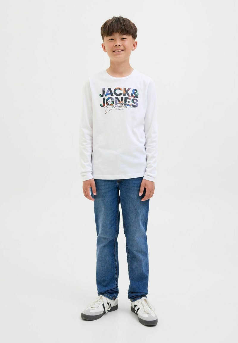 T-shirt bianca a maniche lunghe con grafica "JACK & JONES" multicolore. Abbinata a jeans blu e sneakers grigio-neri con dettagli bianchi.