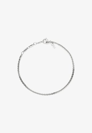 Bracelet délicat en chaîne argentée avec fermoir mousqueton et petite étiquette de marque sur fond blanc.