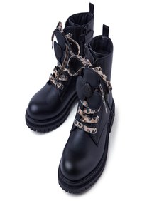 Botas de tobillo de cuero negro con cordones de estampado de leopardo. Suela gruesa, cierre de cremallera en el lateral y un adorno en forma de flor en los cordones.