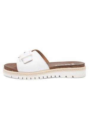 White slip-on sandal with wide adjustable buckle strap, brown cushioned footbed, woven midsole detail, and white ridged rubber outsole.