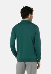 Langärmliger Polo-Pullover in Dunkelgrün, mit strukturierter Stoffqualität, geripptem Kragen und Bündchen, geradem Saum und minimaler Detailgestaltung.