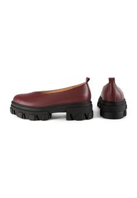 Burgundy leather shoes with a rounded toe, chunky black rubber sole, and a back loop for easy wear, featuring a smooth texture.