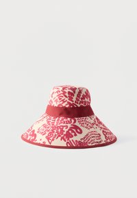 Sombrero beige de ala ancha con texto rojo estilo grafiti y una banda roja sólida alrededor de la corona.