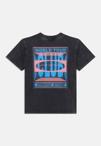 Tmavohnedé tričko s farebnou grafickou potlačou a textom „WORLD TOUR CLUB“ spolu s podrobnosťami o udalosti na festivale na Vingino Stage.