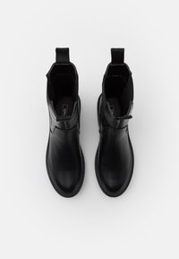 Black leather ankle boots with elastic side panels and pull tabs. Smooth texture and rounded toe with stitching detail along the sole.