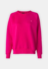 Luddigt, ljusrosa sweatshirt med rund hals och långa ärmar. Har en liten logotyp på bröstet samt ribbade manschetter och nederkant.